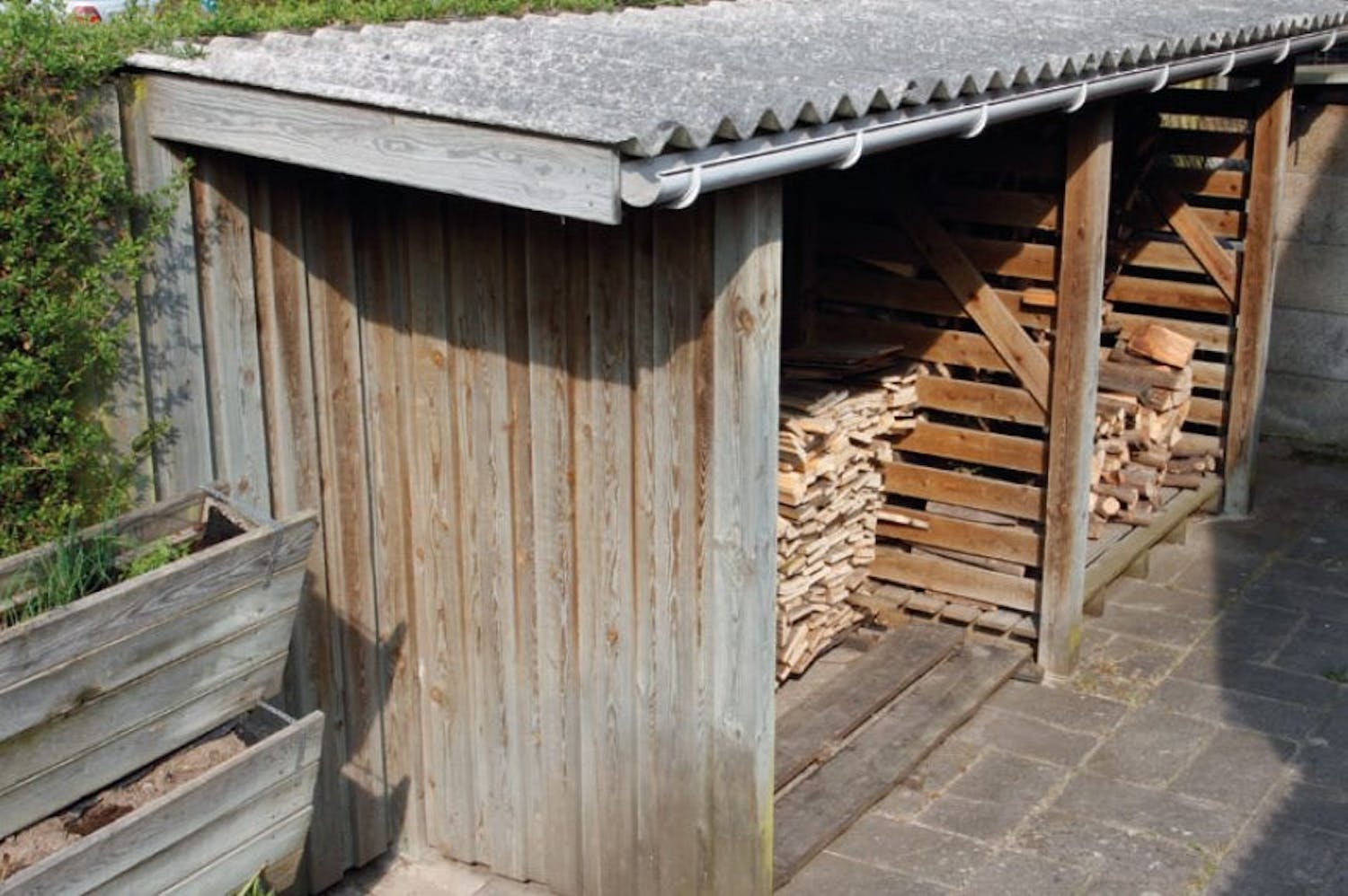 Bygg vedboden längs staketet